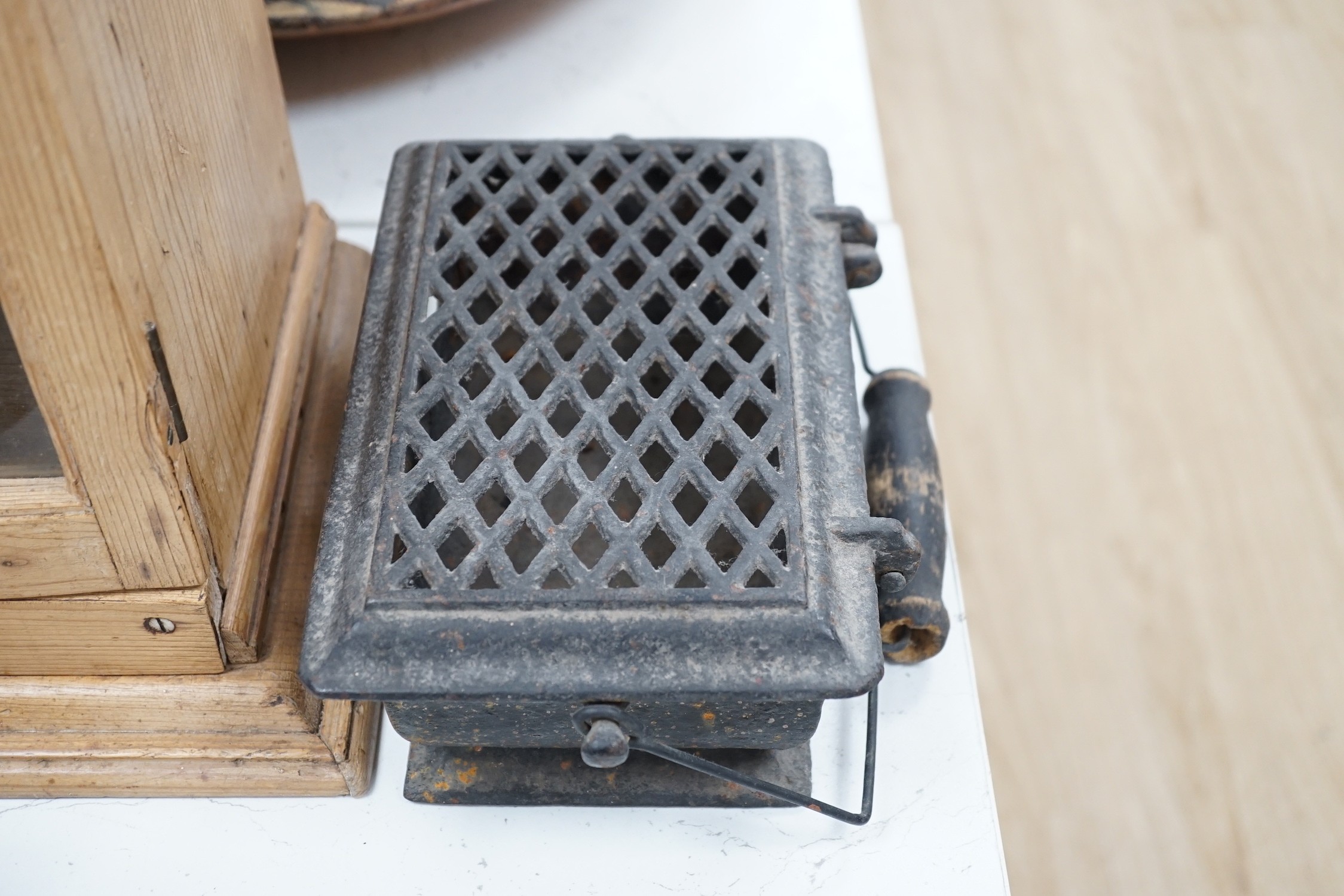 Four French coal/slug irons, three trivets and a stripped pine glazed cabinet, 37cm high